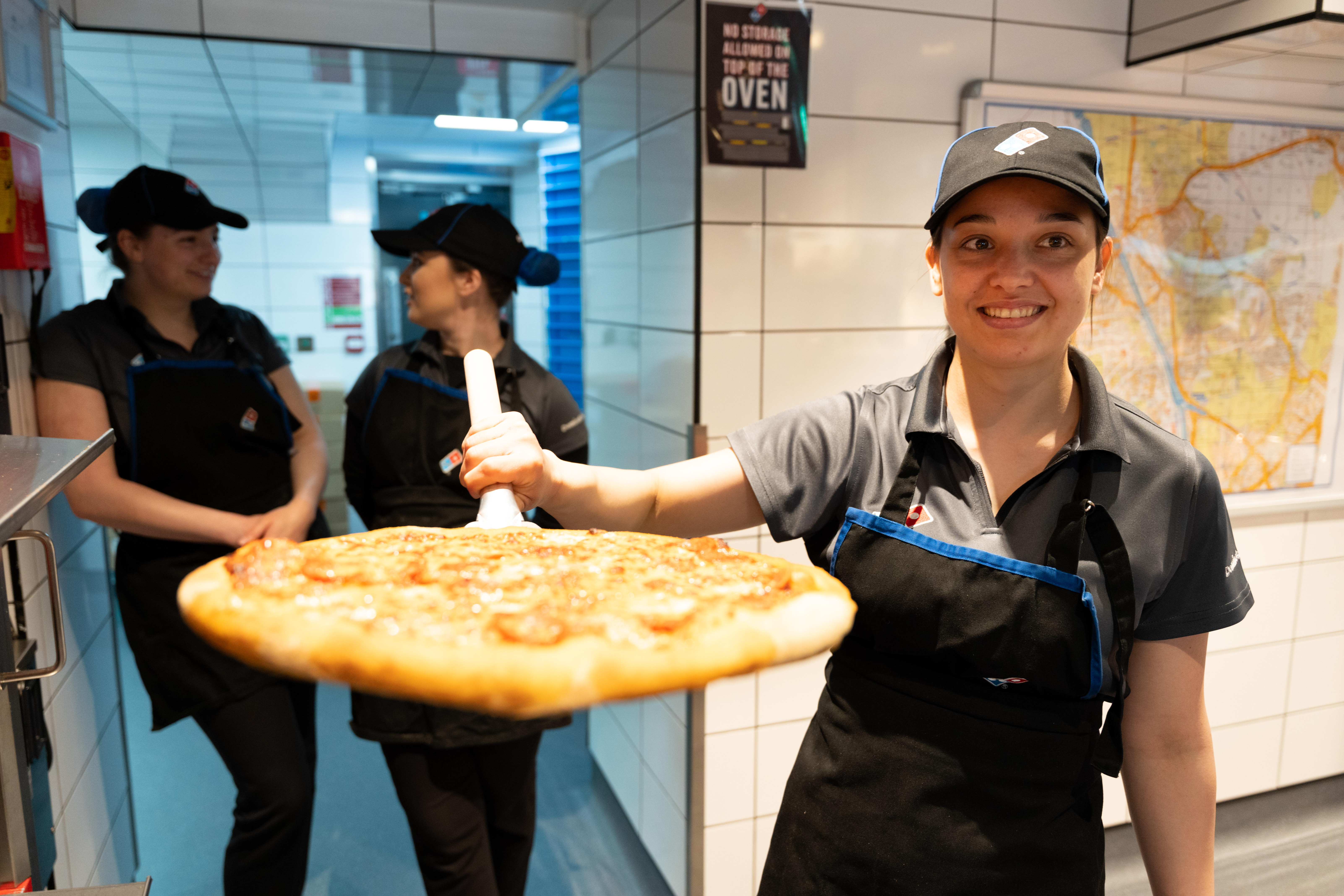 team member skills required - Colleague in store with pizza.